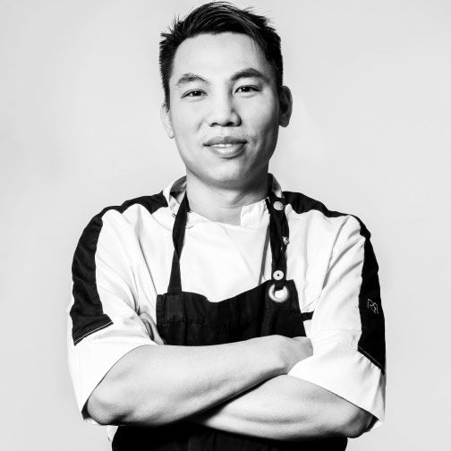 Portrait de Duy Phong en noir et blanc, les bras croisés