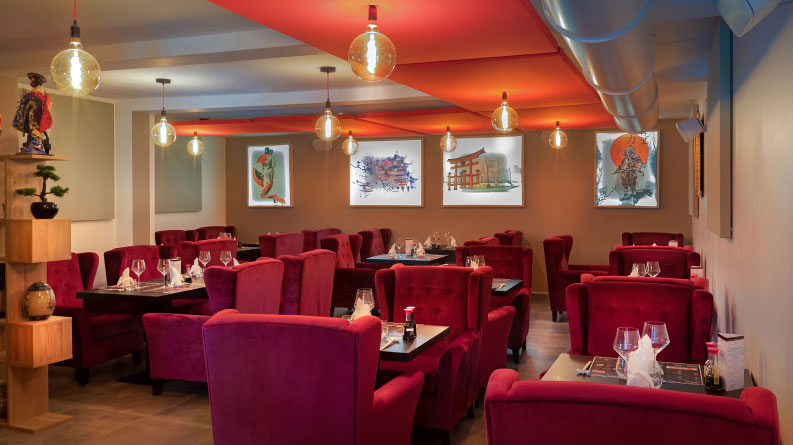 salle de restaurant japonais avec de grands fauteuils rouges