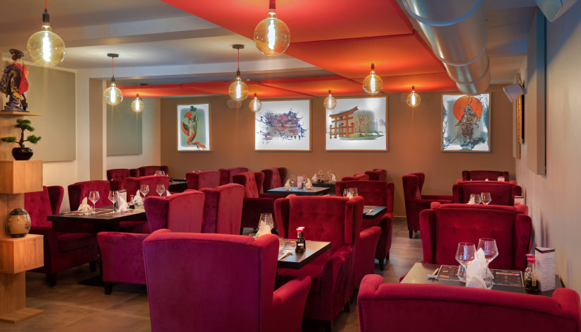 salle du restaurant du japon, avec de grands fauteuils rouges